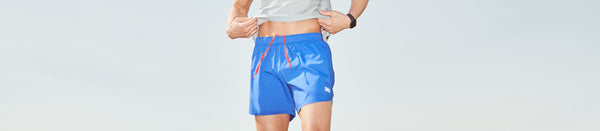 Man in blue shorts and shirt standing outside