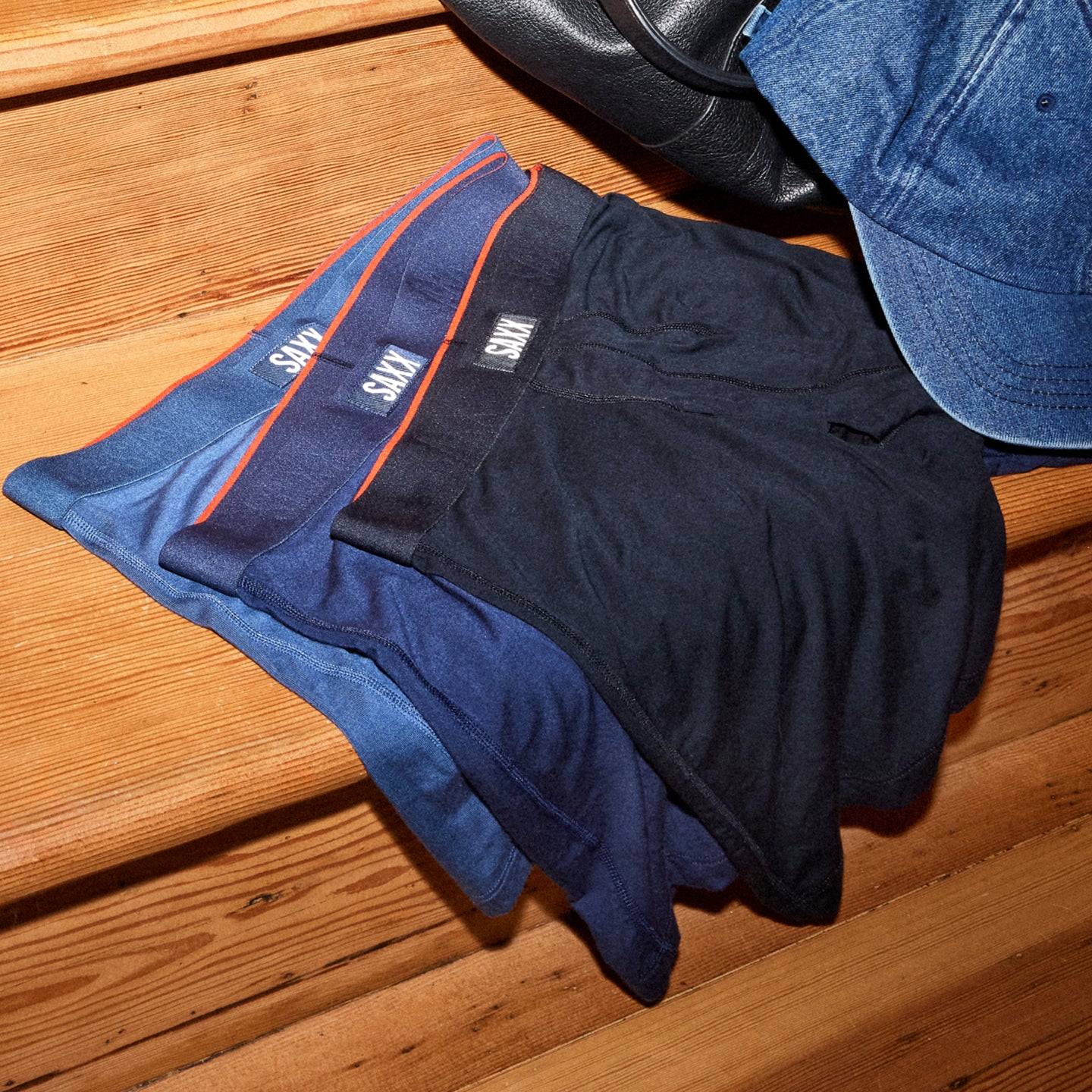 Navy shorts with orange trim on a wooden surface