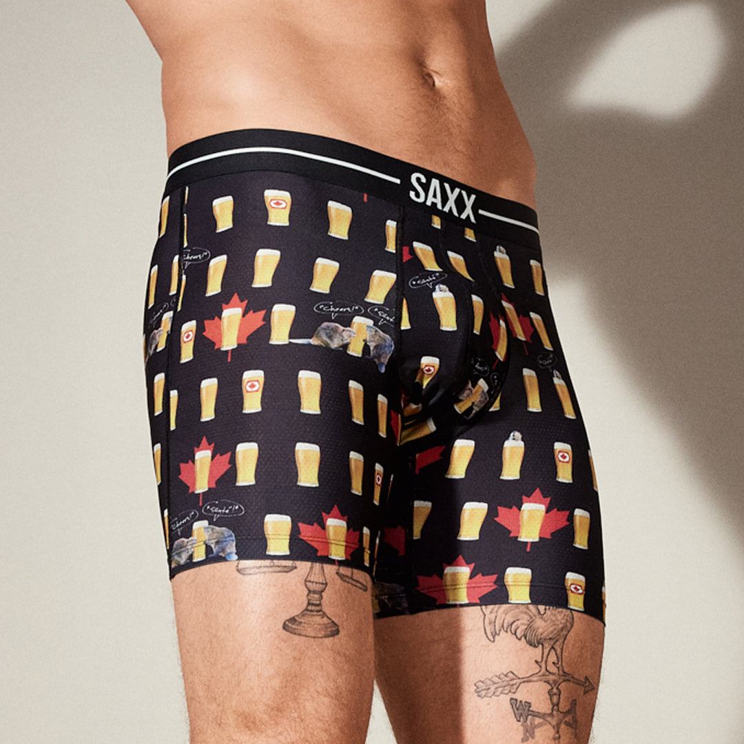 Mens underwear with beer mug pattern and Saxx branding on a neutral background