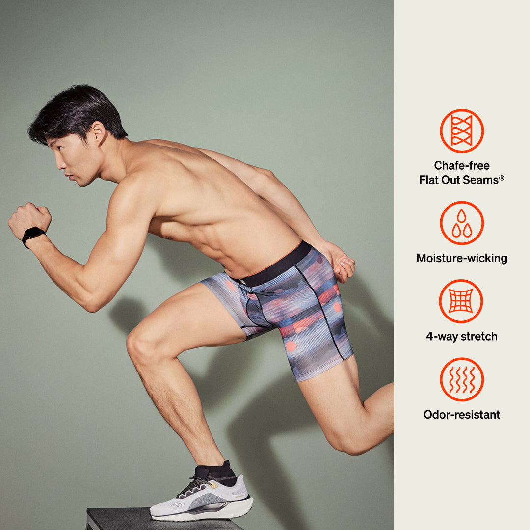 Man running wearing striped athletic shorts with product features on the side.