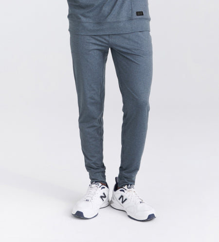 Man wearing gray sweatpants and white running shoes