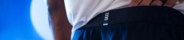 Back of man in blue sleep pants and white shirt