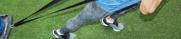Man in striped tights and blue shirt pulling sled
