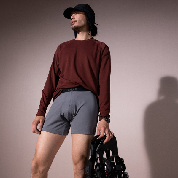 Model posing in Roast Master Mid-Weight Baselayer Long Sleeve Crew in Dark Brick