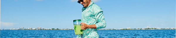 Man in long sleeve cooling tee along water holding pitcher of green liquid