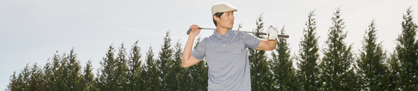 Man in cap and golf shirt holding club