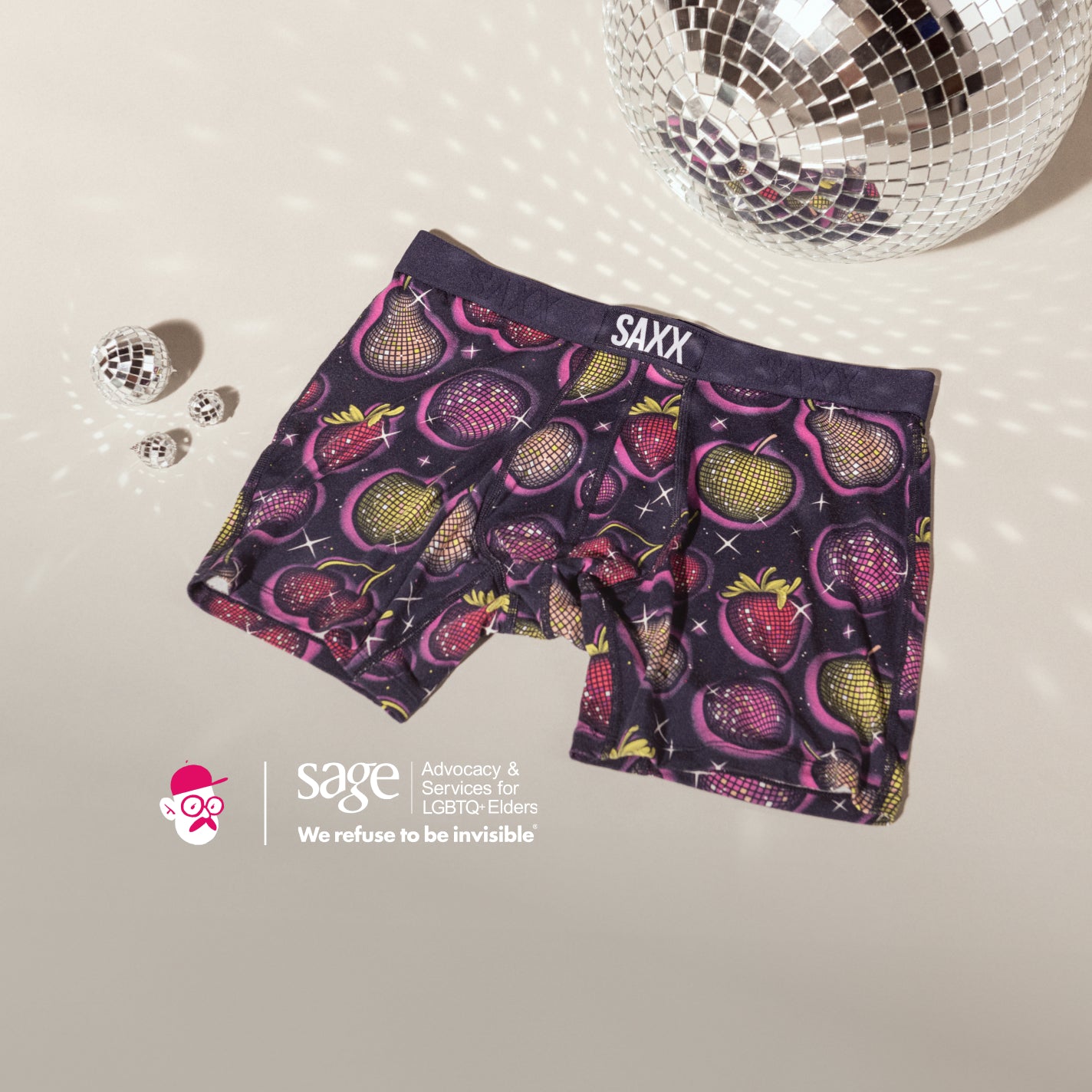 SAXX and artist Kyle Letendre logos overlaying a photo of disco balls surrounding purple boxer briefs in a fruit print