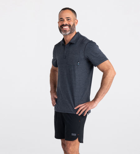 Man wearing navy polo shirt and black shorts