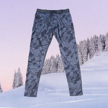 Graphic with baselayer tights in gray swirly pattern overlaying snowy mountains