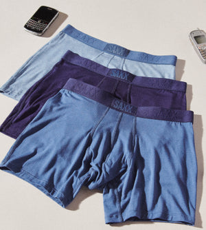 Three Boxer Briefs in different shades of blue surrounded by old cellphones