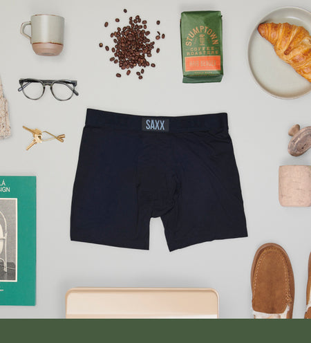 Black pair of boxer briefs surrounded by household items such as coffee beans and keys