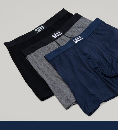Three boxer briefs in black grey and blue arranged on top of one another