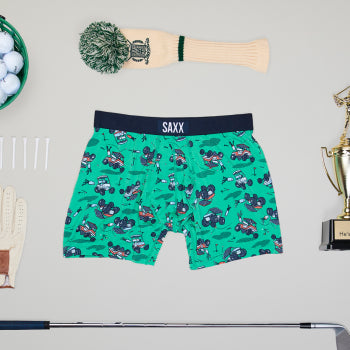  Green patterned boxer brief surrounded by golf equipment such as club tees and balls