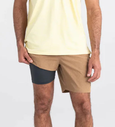 Man wearing a yellow shirt and beige shorts with a liner
