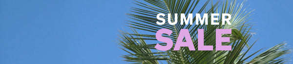 Summer Sale text in purple and white font overlaying a photo of palm trees