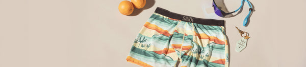 Boxer briefs in a print by artist Erik Abel surrounded by oranges and a pair of sunglasses