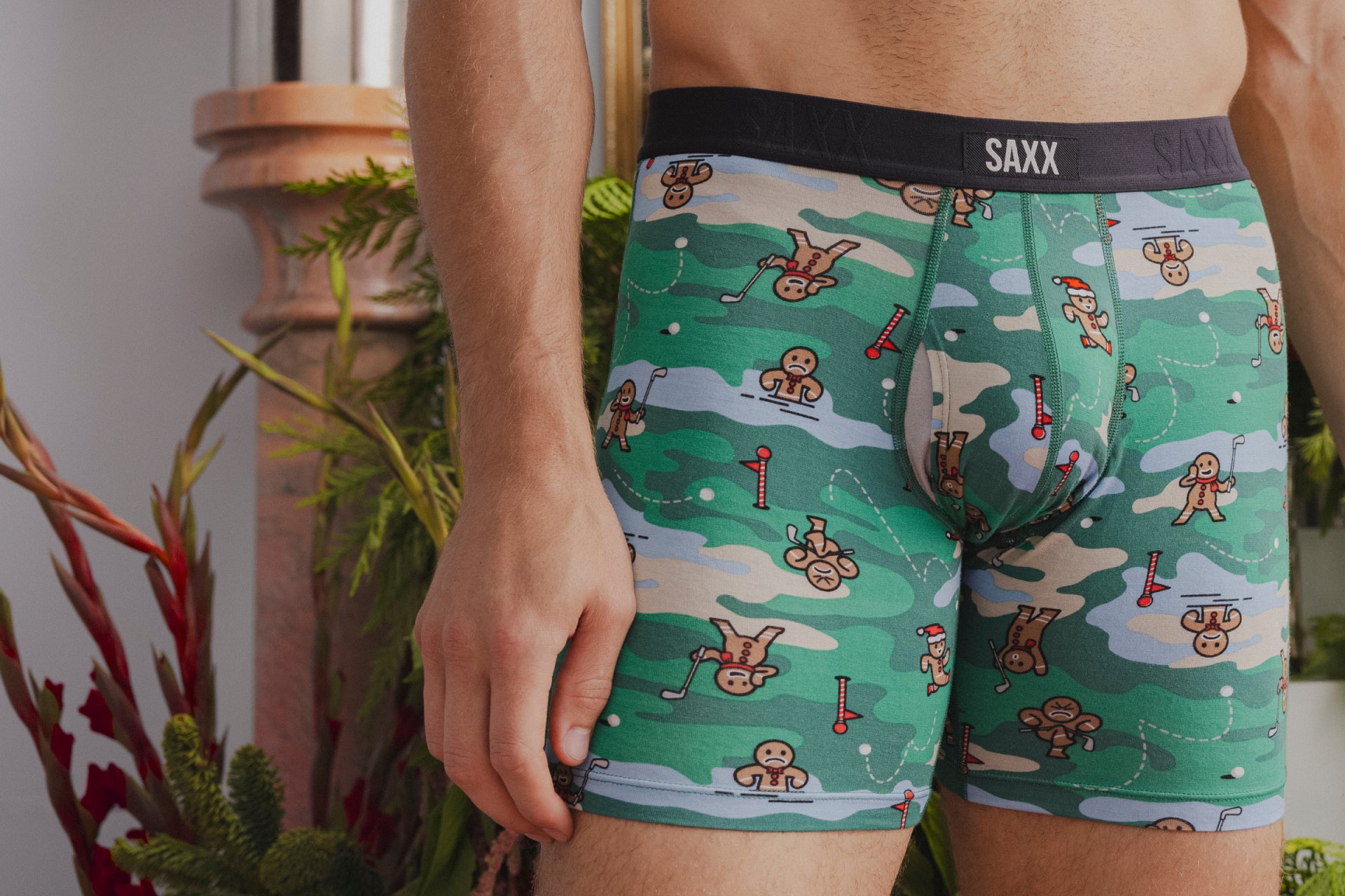 A close up image of a pair of underwear with gingerbread men playing golf printed on them.