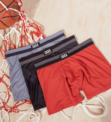 Three pairs of Boxer Briefs in different colors next to a basketball and basketball net