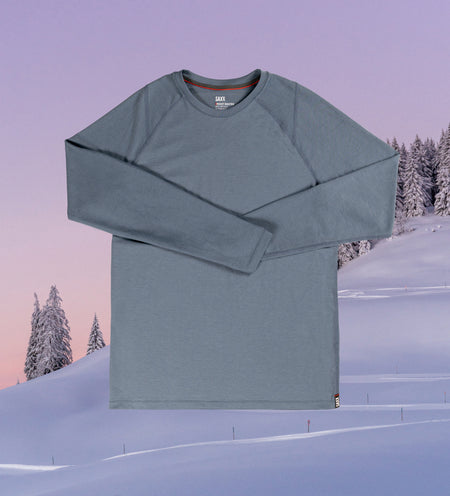 Gray baselayer top overlaying a photo of snowy mountains