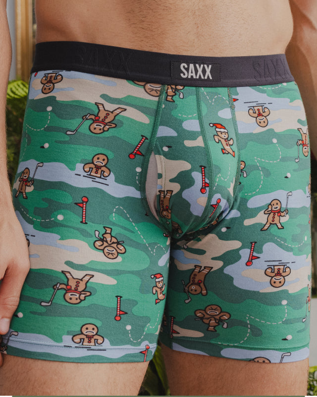 A close up image of a pair of underwear with gingerbread men playing golf printed on them.