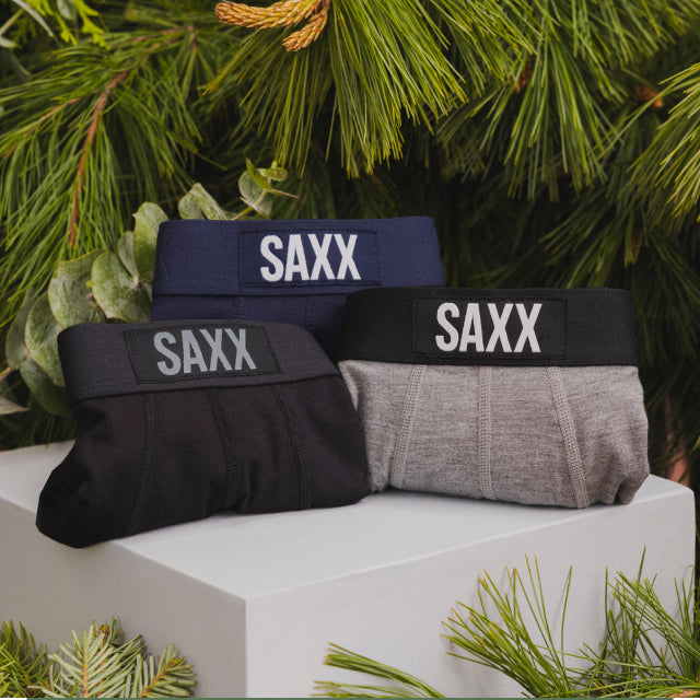 Three pairs of underwear on a white box. One is black. One is blue. One is grey.