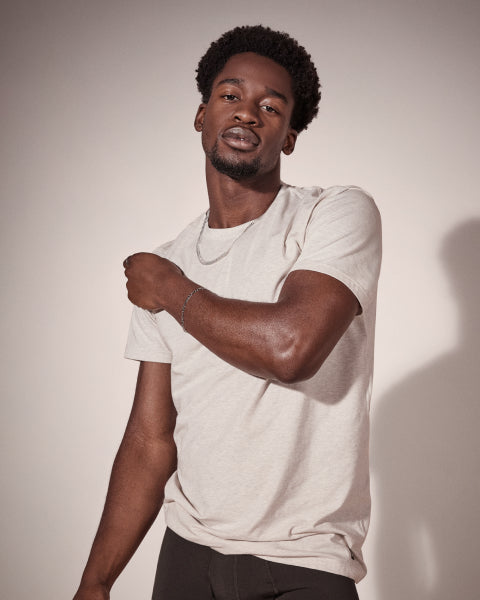 Man wearing a light gray t-shirt against a plain background