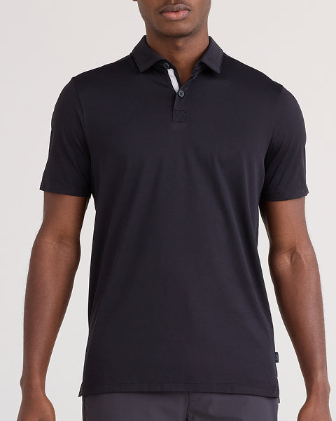 Man wearing a black polo shirt on a plain background