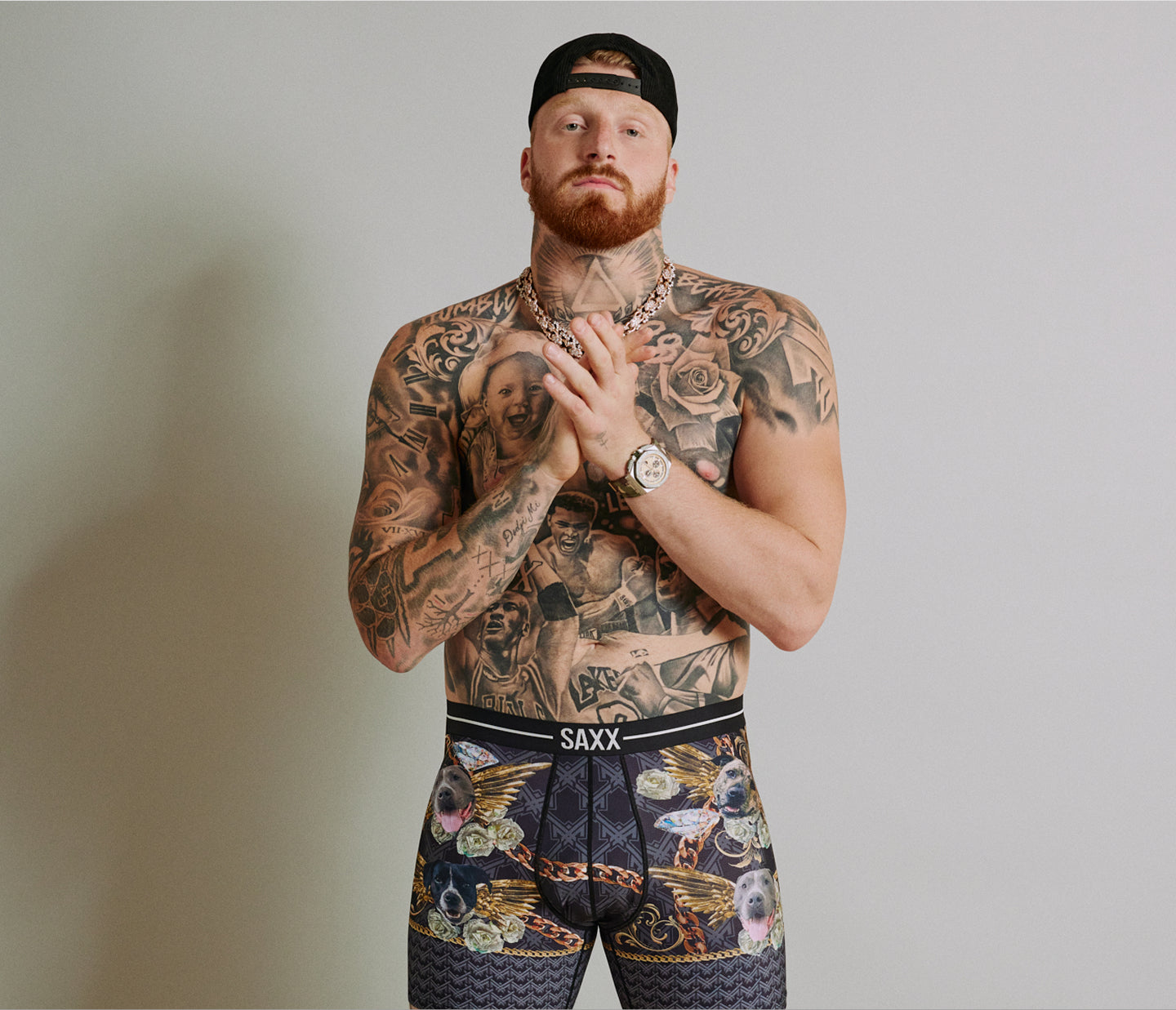Man with tattoos wearing SAXX underwear against a plain background