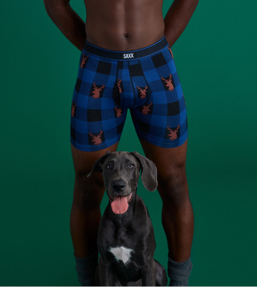 Shirtless man in underwear with happy dog in between his legs