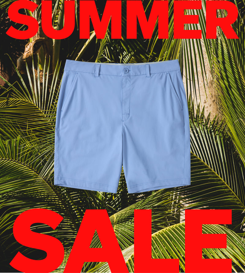 Blue shorts on a tropical leaf background with 'Summer Sale' text.
