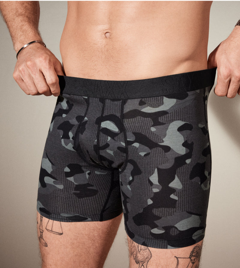 Camouflage-patterned boxer briefs worn by a person against a neutral background