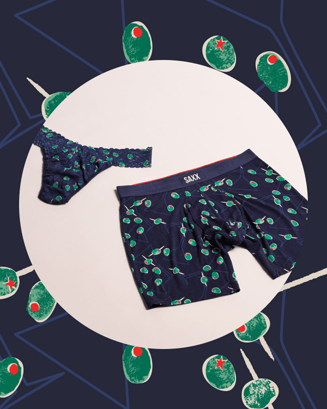 Navy boxer briefs with green pattern on a white plate against a dark blue background with green decorative elements.