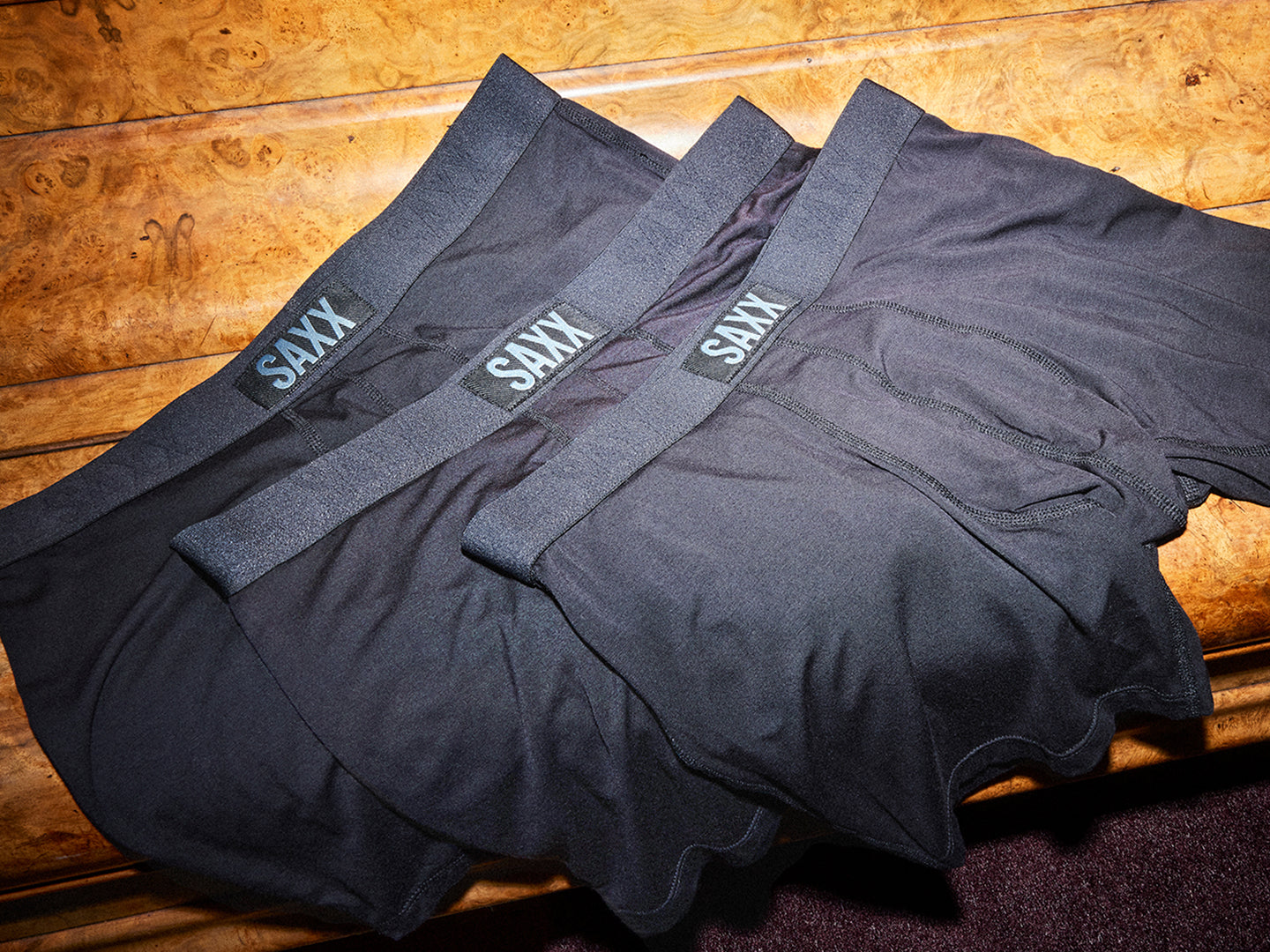 3 pairs of Black Saxx Underwear on a wooden background