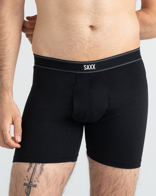 Model wearing black boxer briefs with 'SAXX' branding on a plain background