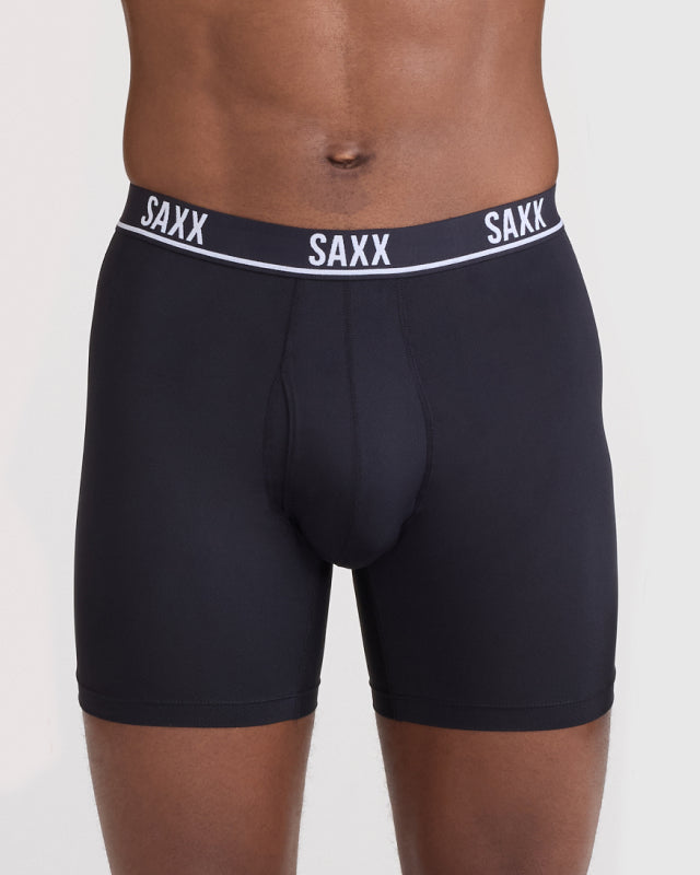 Model wearing black boxer briefs with 'SAXX' branding on a plain background