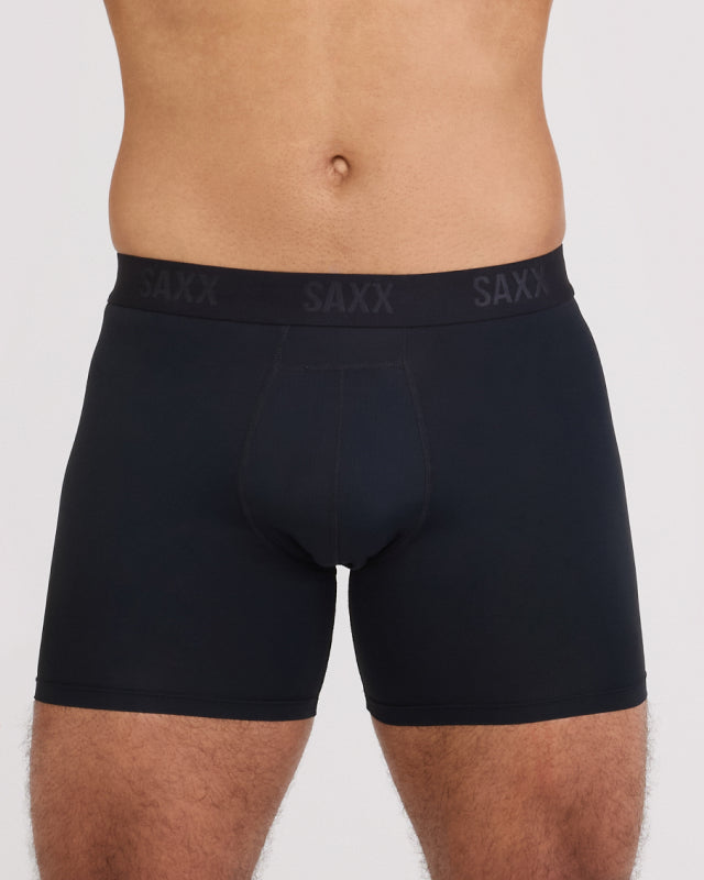 Model wearing black boxer briefs with 'SAXX' branding on a plain background