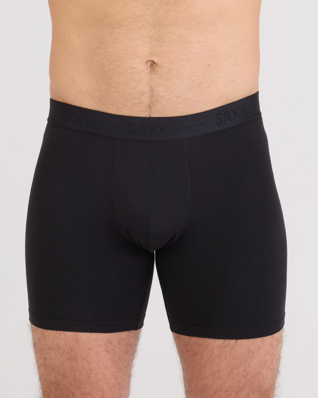 Model wearing black boxer briefs with 'SAXX' branding on a plain background