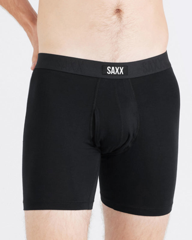 Model wearing black boxer briefs with 'SAXX' branding on a plain background