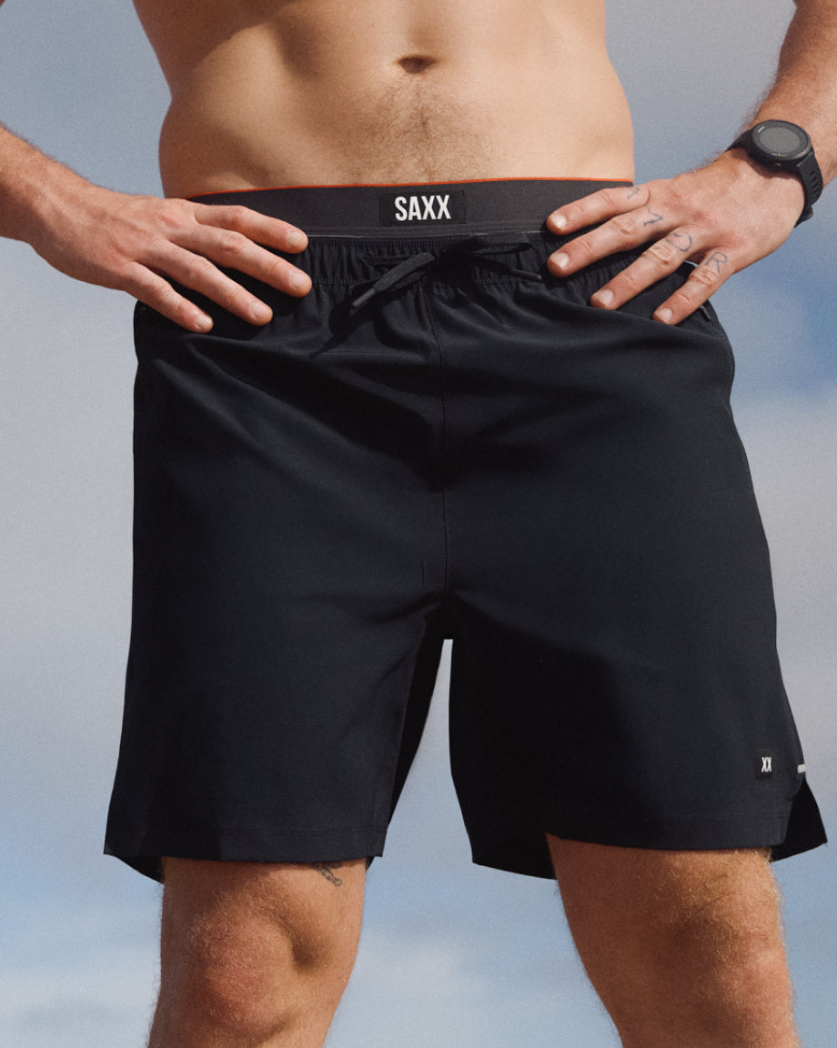 Person wearing black SAXX shorts with a blurred background