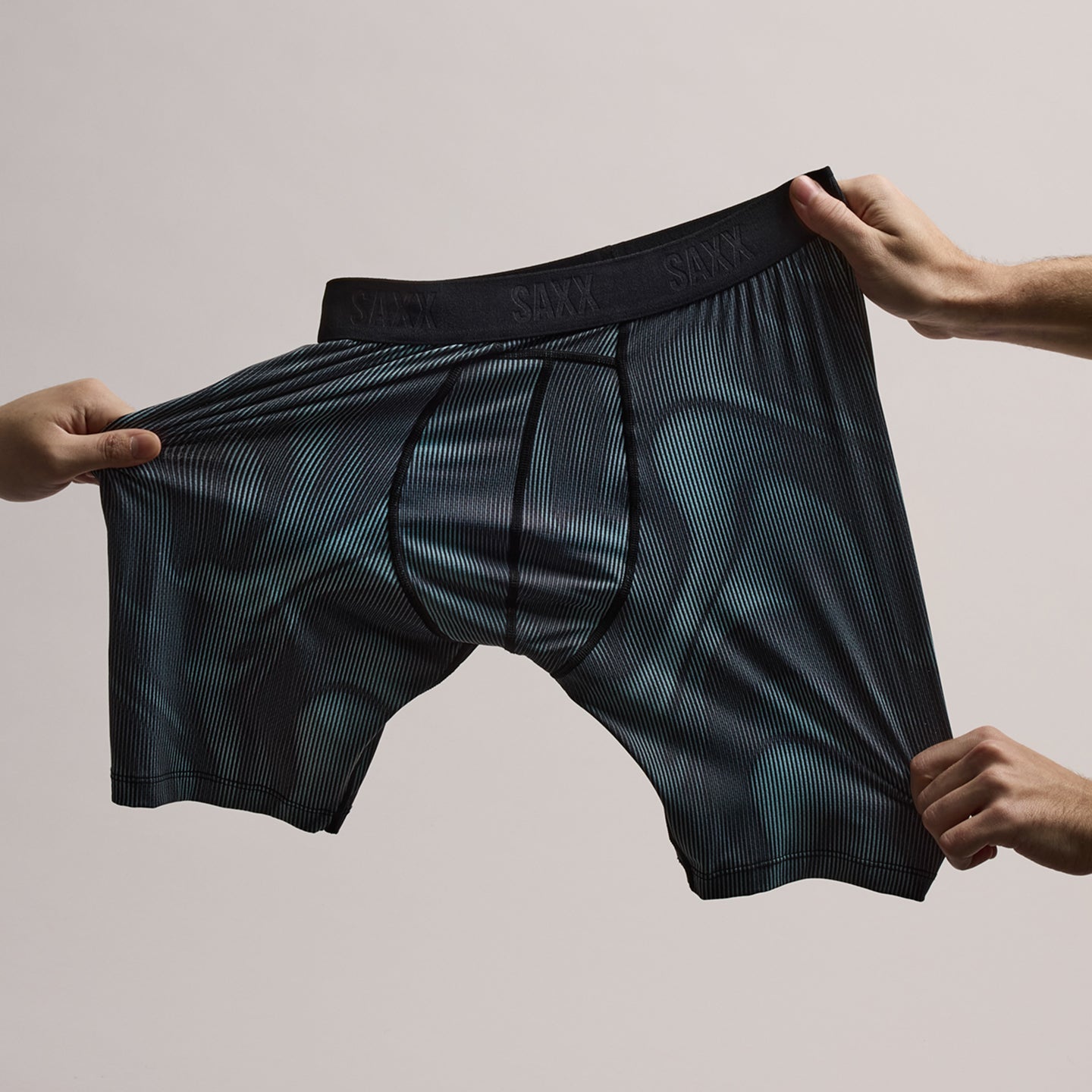Black patterned SAXX boxer briefs stretched and held up against a plain background