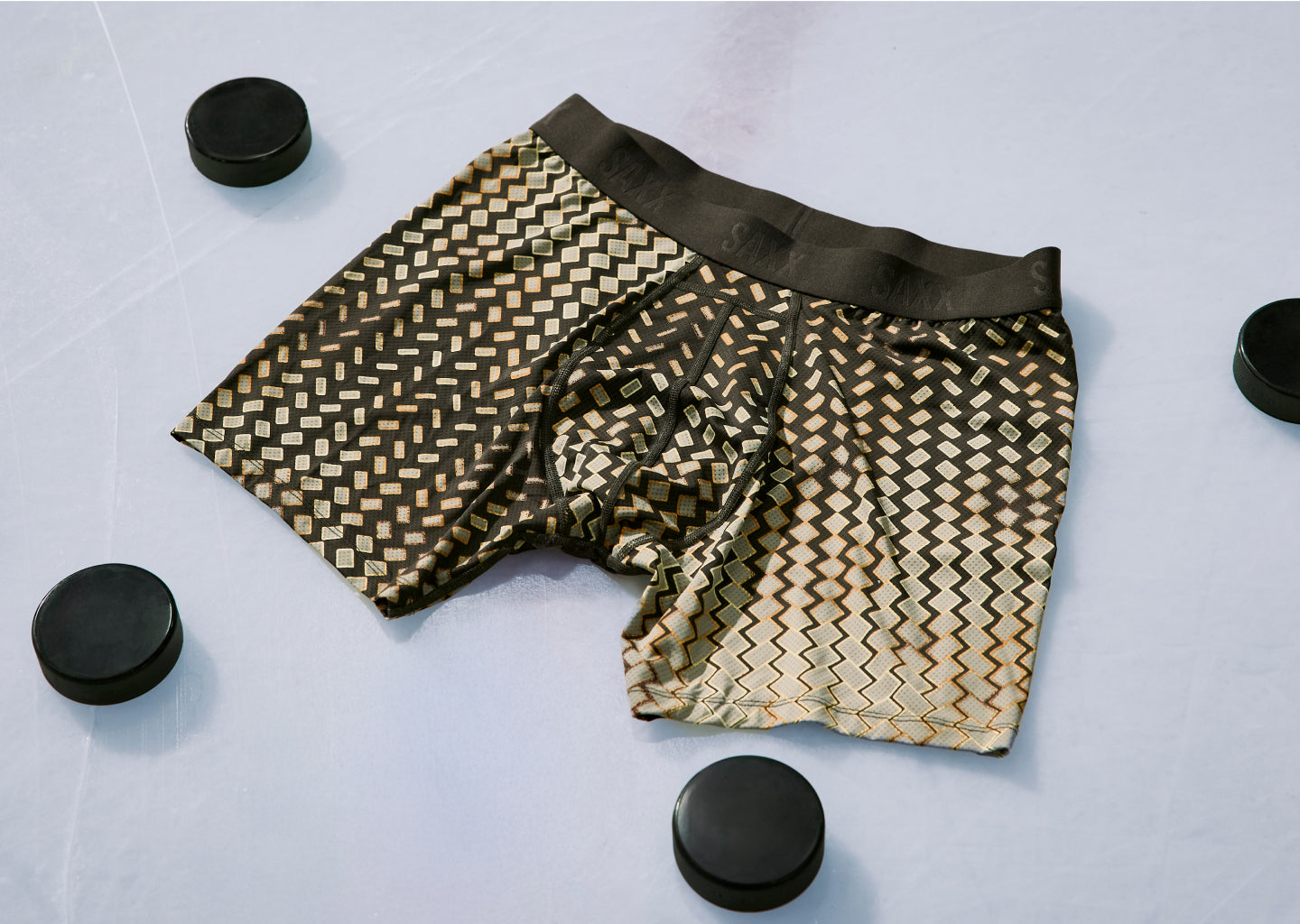 Patterned boxer briefs on a light gray background with black circular objects.