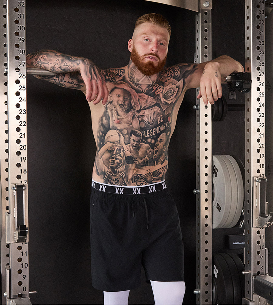 Pro Football Player Maxx Crosby posing in SAXX performance apparel in a gym.