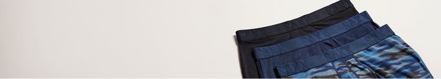 Pairs of SAXX Underwear overlayed on top of each other in shades of blue.
