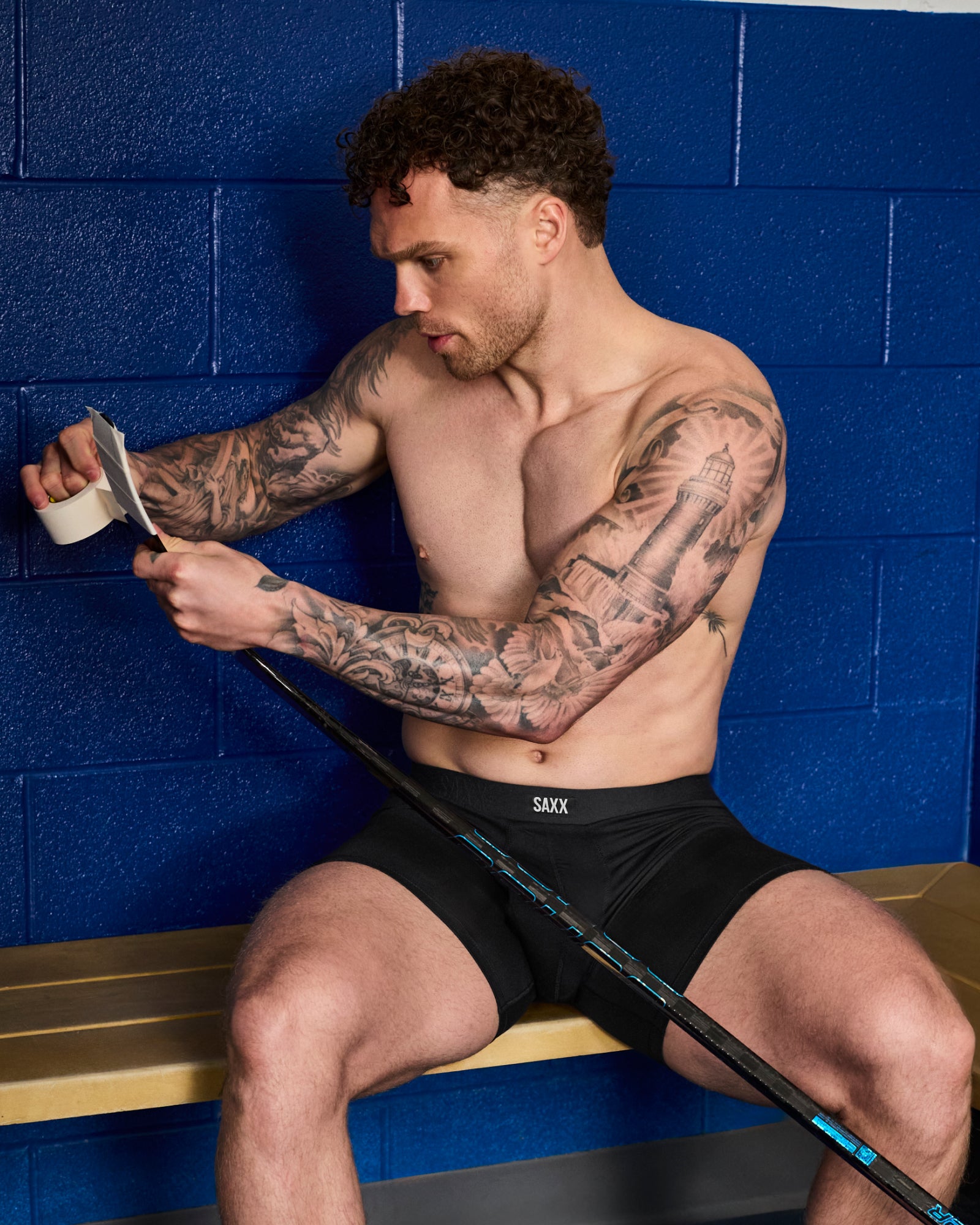 Max Domi wearing black Vibe Xtra boxer brief underwear in locker room taping a hockey stick showcasing everyday supportive comfort