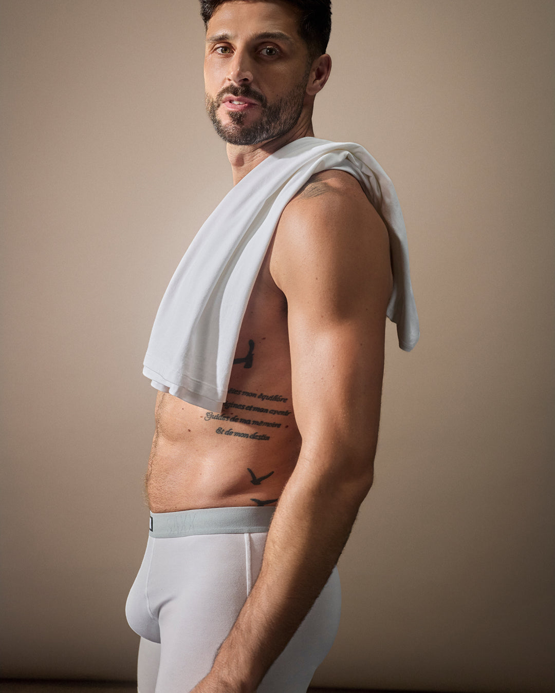 Male model wearing light color SAXX underwear shown from side angle highlighting smooth fit and comfort