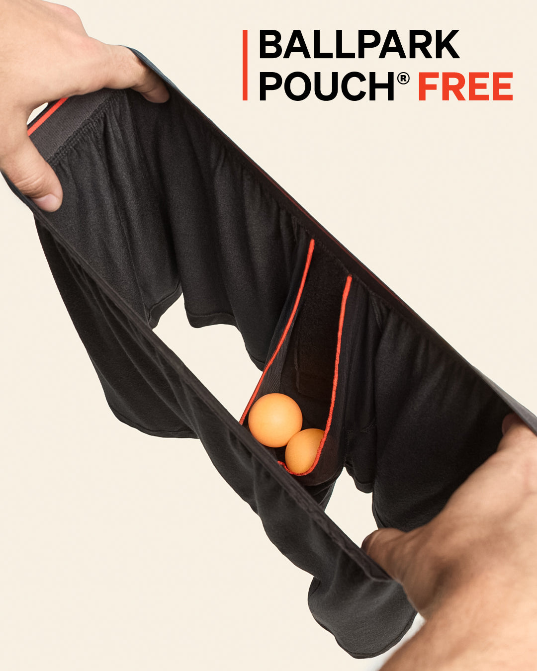 Person holding a black baseball bat with an orange ball inside, against a beige background.