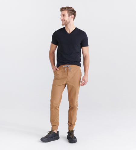 Man wearing beige joggers and black V neck