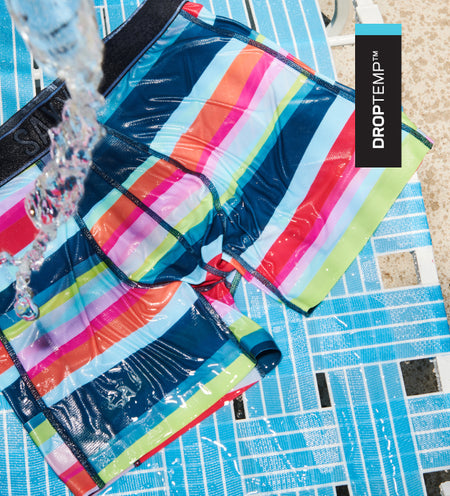 Striped aquatic boxer briefs on beach chair with water being poured on it