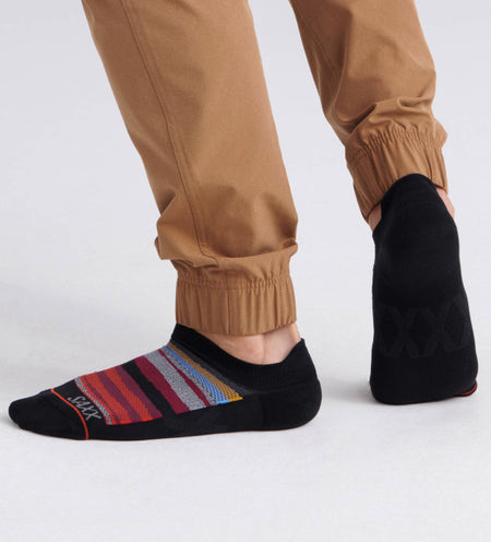 Man wearing black low show socks with stripes in different colors