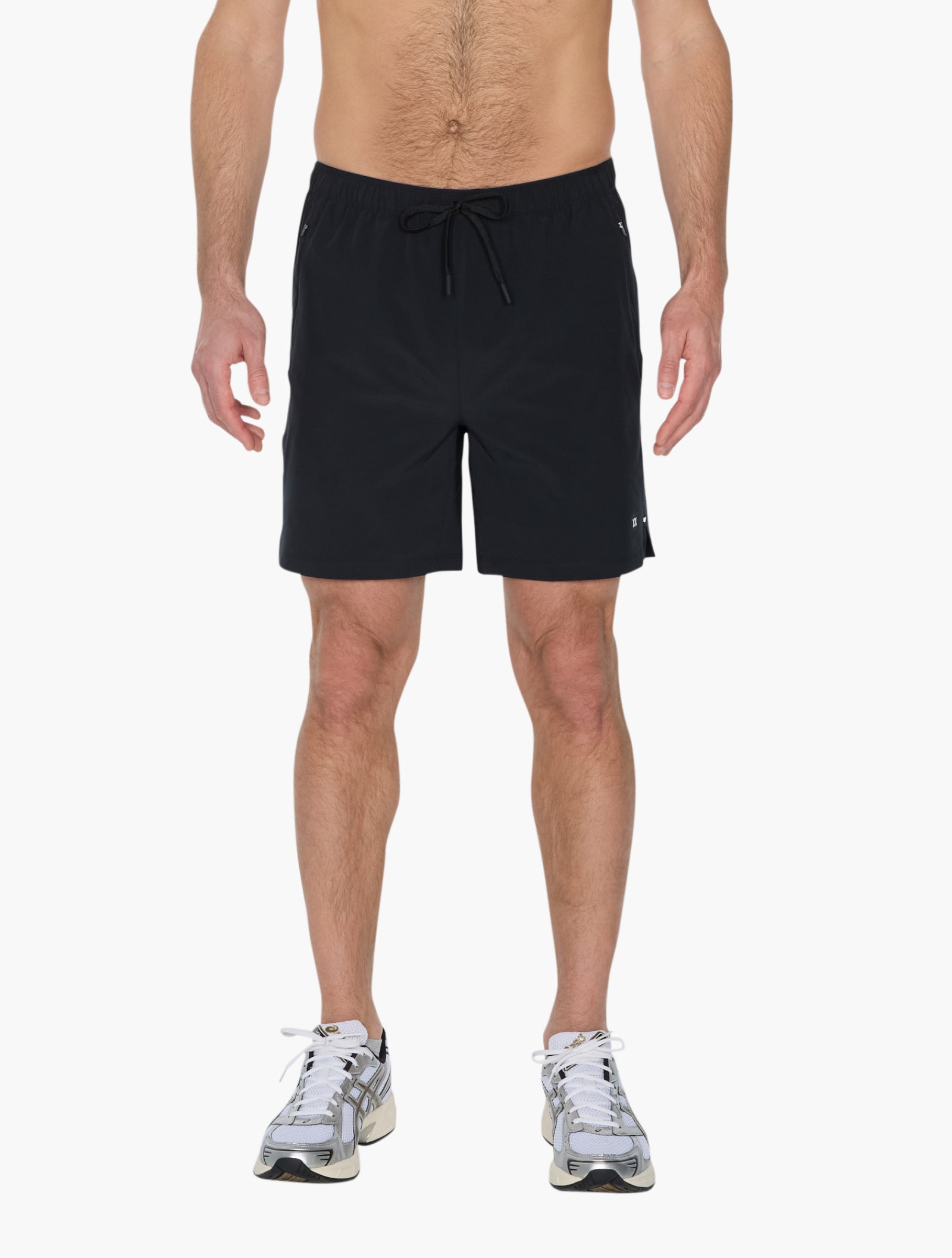 Man wearing black performance shorts standing facing forward with drawstring waist and running shoes visible